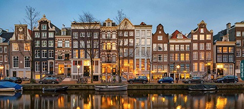 row of Amsterdam canal houses in twilight