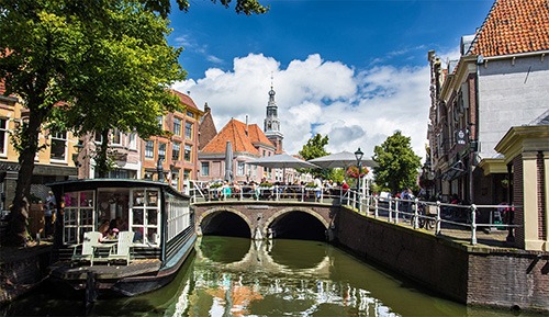 alkmaar canal with picturesque view on church and bridge