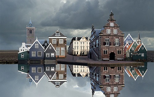 city hall and houses refected in canal de Rijp
