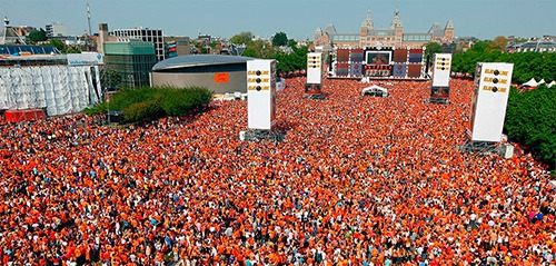 a kingsday concert at museum square attended by thousends of orange dressed Dutchmen